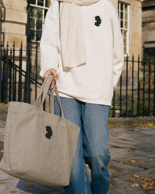 The Wayfarer canvas tote carried by a student walking in Edinburgh, wearing the Cameo sweatshirt